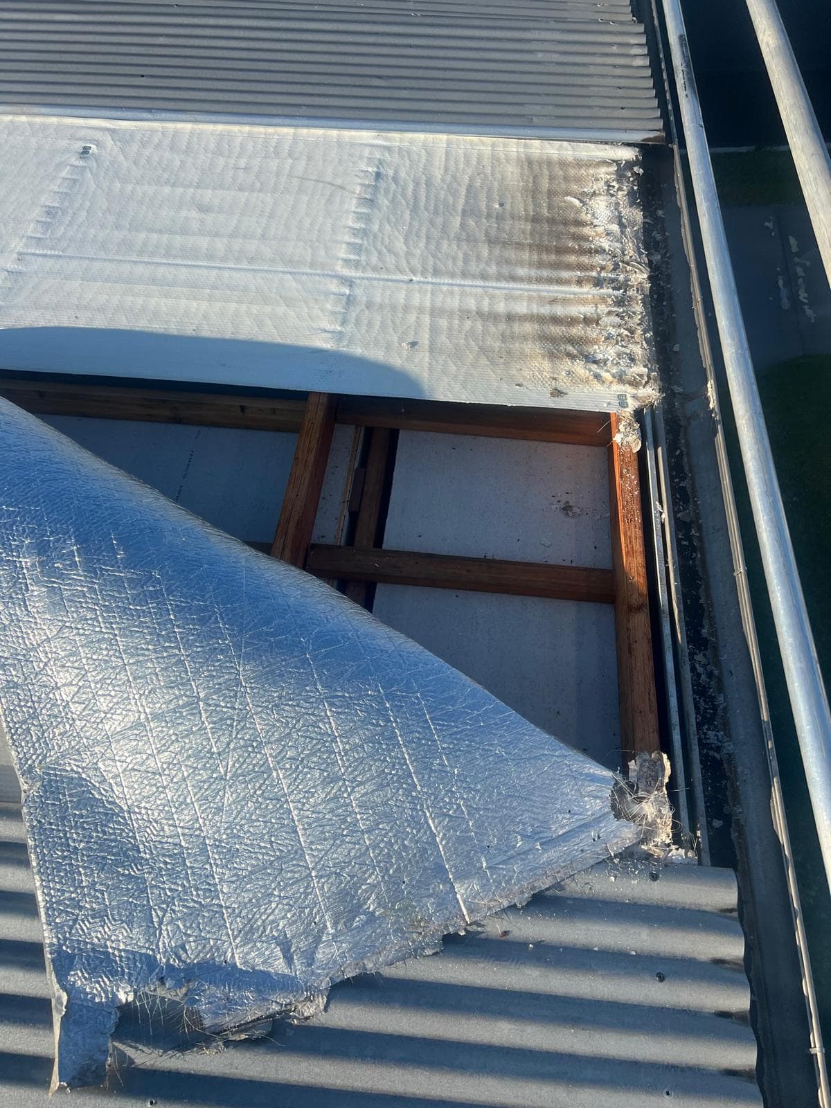 Old metal roof sheets removed and new insulation being laid on the roof structure in Lota, Brisbane