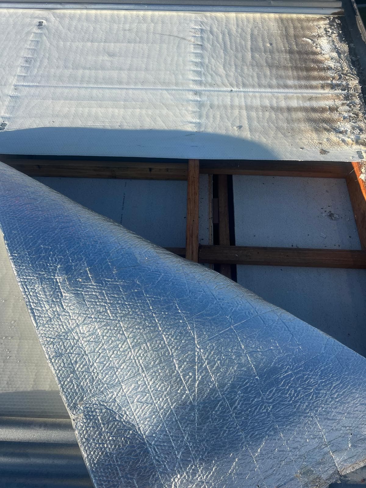Roof insulation blanket being installed before new Colorbond sheeting in Lota, Brisbane
